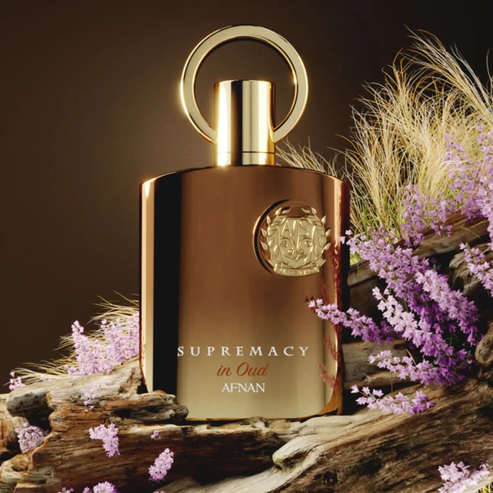 Frasco del perfume Supremacy in Oud Afnan Eau de Parfum Unisex con un fondo de lavanda y madera